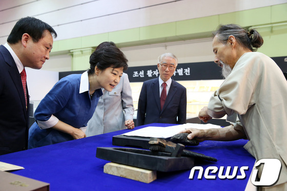(서울=뉴스1) 박철중 기자 = 박근혜 대통령이 19일 오전 서울 코엑스에서 열린 '2013 서울국제도서전 개막식'에 참석, 조선활자 책 특별전 부스에서 직지인쇄 시연을 보고 있다 …