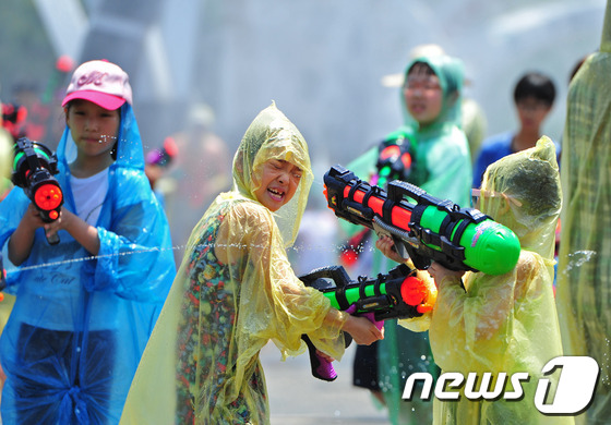 (무주=뉴스1) 김대웅 기자 = 제17회 무주반딧불축제가 열리고 있는 2일 전북 무주군 남대천 다리위에서 '더위야 가라~'물 벼락 페스티벌에 참가한 어린이들이 물총을 쏘며 즐거운 …
