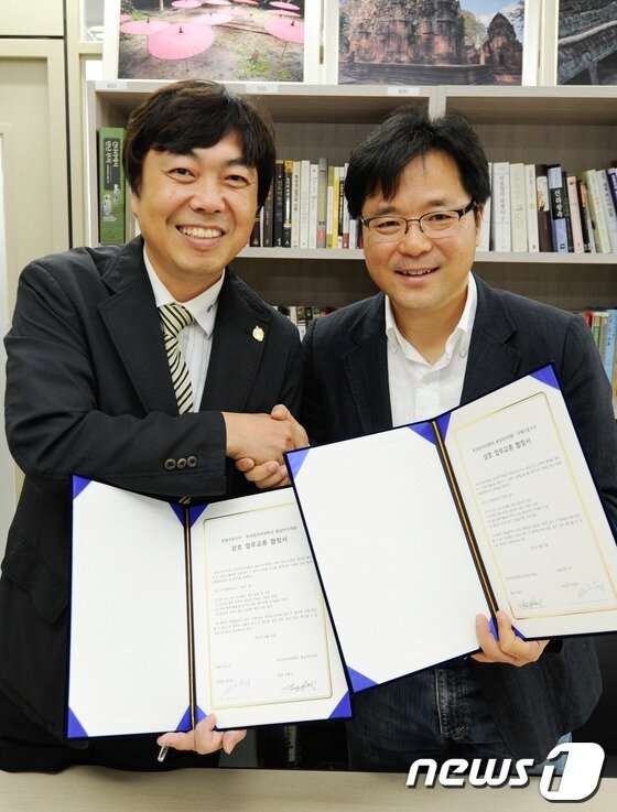 본문 이미지 - 22일 오전 부산 외국어대학교 동남아지역원에서 박장식 동남아지역원장(오른쪽)과 이진우 국제구호기구 이사장이 MOU체결을 맺고 악수를 하고 있다. 2013.6.23/뉴스1 © News1 전혜원 기자