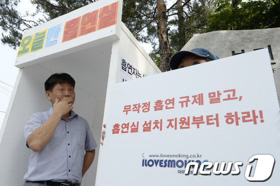 (서울=뉴스1) 안은나 기자 = 흡연자 커뮤니티 '아이러브스모킹' 회원이 27일 오전 서울 종로구 계동 보건복지부 앞에서 공공장소 흡연실 설치를 촉구하며 임시 흡연실을 설치해 흡연 …