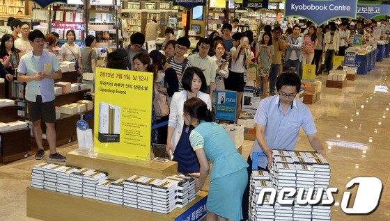 본문 이미지 - 무라카미 하루키의 새 장편소설 '색채가 없는 다자키 쓰쿠루와 그가 순례를 떠난 해' 국내 첫 출간일인 지난 7월1일 서울 광화문 교보문고에서 독자들이 책을 구입하기 위해 길게 줄을 선 가운데 직원들이 책을 진열하고 있다. 하루키가 3년 만에 내놓은 이 책은 마음에 상처를 입은 한 남성의 회복과 연애를 다룬 것으로 일본에서 발매 6일 만에 발행 부수 100만부를 기록하는 등 큰 인기를 끌었다. 2013.7.1/뉴스1 © News1   안은나 기자