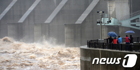 (연천=뉴스1) 손형주 기자 = 12일 경기도 연천군 군남면 군남홍수조절지에서 주민들이 물이 하류로 쏟아지는 모습을 바라보고 있다. 현재 임진강 홍수조절용인 군남댐 저수위가 최고치 …