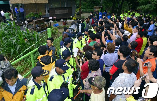 10대 여학생을 성폭행하고 목 졸라 살해한 뒤 시신을 훼손한 용인 살인사건 피의자 S가 2013년 7월 12일 오후 용인시 이동면 자택에서 현장검증을 했다. 주민들이 몰려들어 휴대폰 카메라로 용의자를 촬영하고 있다. 2013.7.12/뉴스1 ⓒ 뉴스1