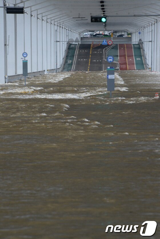본문 이미지 - 중부지방의 집중호우로 14일 서울 한강 잠수교가 통제 수위인 6.2m를 넘어서 차량과 보행자의 통행이 전면 통제되고 있다. 한강홍수통제소는 비는 소강 상태를 보이고 있지만 현재 팔당댐 방류량이 1초에 만여 톤에 달한다며 잠수교 수위가 계속 높아질 것으로 예상한다고 밝혔다. 2013.7.14/뉴스1 © News1   양동욱 기자