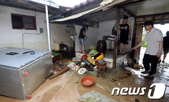 본문 이미지 - 14일 집중호우로 침수피해를 입은 경기도 연천군 신서면 도신3리 한 주택에서 주민들이 복구작업을 벌이고 있다. 기상청은 오늘 경기북부와 강원 중북부를 중심으로 시간당 50mm안팎의 많은 비가 내리겠다고 밝혔다. 2013.7.14/뉴스1 © News1   박세연 기자