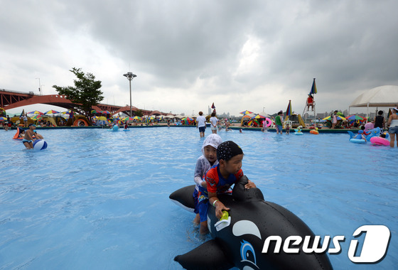 (날씨=뉴스1) 정회성  = 장마가 잠시 멈춘 21일 오후 서울 마포구 망원동 한강망원수영장에서 어린이들이 물놀이를 즐기고 있는 가운데 수영장 하늘에 짙은 먹구름이 끼어 있다. 2 …