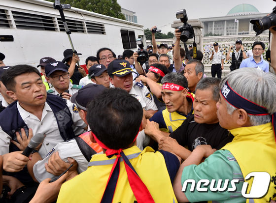 (서울=뉴스1) 안은나 기자 = 전국한우협회 회원들이 24일 오후 서울 여의도 국회의사당 앞에서 소값 회복을 촉구하던 중 소를 데려오기 위해 경찰과 충돌하고 있다. 참가자들은 소고 …