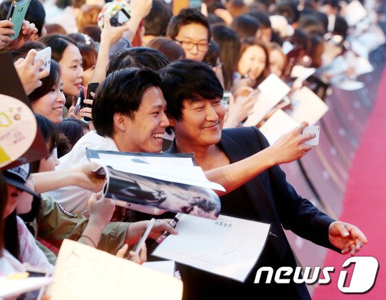 본문 이미지 - 배우 송강호가 지난달 29일 오후 서울 영등포 타임스퀘어에서 열린 영화 &#39;설국열차&#39; 레드카펫 행사에서 팬과 스마트폰으로 셀카를 찍고 있다. 2013.7.29/뉴스1 © News1 