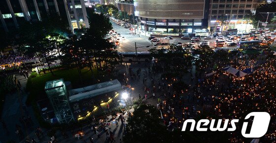 본문 이미지 - 국정원 정치개입 규탄 제6차 범국민 10만대회 참가자들(사진 오른쪽)이 10일 오후 서울광장에서 촛불을 켜고 집회를 하는 동안, 경우회 및 한국자유총연맹 등 보수단체 회원들이 인권위원회 앞(사진 왼쪽)에서 맞불집회를 열고 있다. 2013.8.10/뉴스1 © News1 박철중 기자