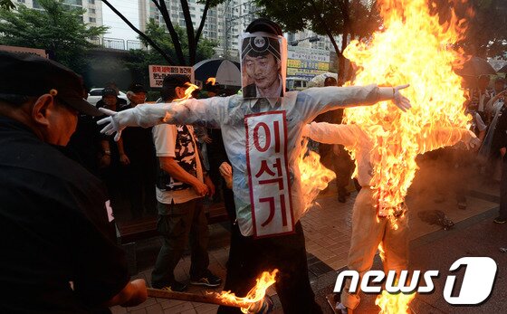 본문 이미지 - 대한민국상이군경회 회원들이 29일 오전 서울 동작구 대방동 통합진보당사 앞에서 이석기 의원의 내란음모 규탄 집회를 갖고 이정희 대표와 이 의원이 그려진 인형에 화형식을 하고 있다. 2013.8.29/뉴스1 © News1   양동욱 기자