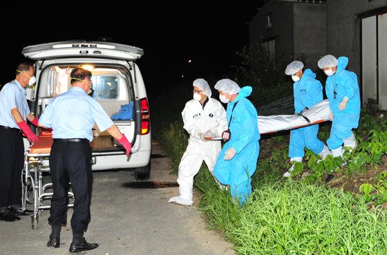본문 이미지 - 3일 오전 경찰에 붙잡힌 정모 경사가 이씨를 살해했다고 자백한 가운데 경찰들이 전북 군산시 회현면 월연리의 폐양계장 막사 사이에서 암매장한 시신을 수습하고 있다.2013.8.3/뉴스1 © News1   김대웅 기자