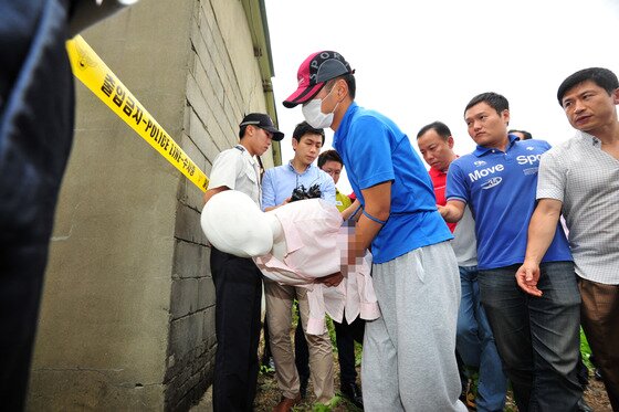 본문 이미지 - 군산 실종 여성 살해 현장 검증이 실시된 3일 오후 전북 군산시 회현면 월연리 소재 폐창고에서 피의자 정모 경사가 목졸라 살해한 이씨의 시신을 옮기는 상황을 재연하고 있다.2013.8.3/뉴스1 © News1   김대웅 기자