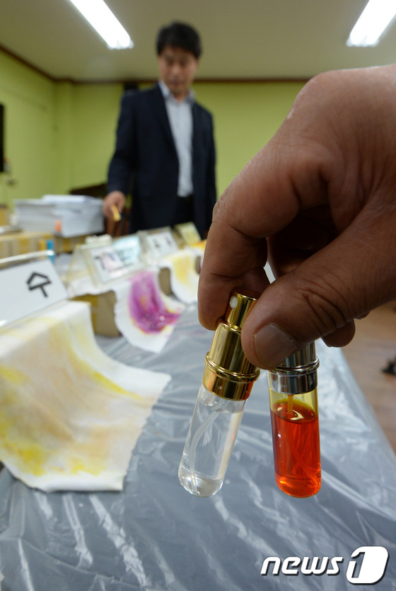 (서울=뉴스1) 박지혜 기자  = 16일 서울 동작경찰서에서 경찰관계자가 압수한 가짜 '불륜시약'을 들어보이고 있다.동작경찰서는 이날 정액에 반응해 배우자의 속옷에 뿌리면 외도 여 …