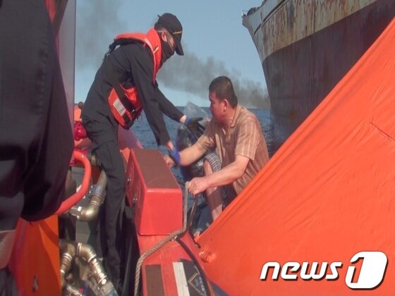 본문 이미지 - 18일 오전 7시25분께 독도 남동쪽 해상 어선에 화재가 발생해 인근에 있던 상선과 경비함정의 구조로 승선원 37명 전원 구조됐다. 화재가 난 승선의 선원이 구조되고있다. (사진제공=동해해경)2013.9.18/뉴스1 © News1  