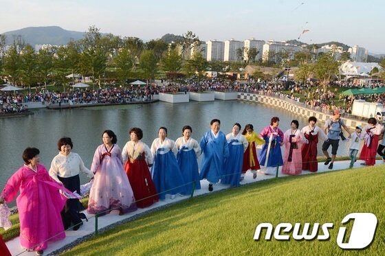 본문 이미지 - 조충훈시장(가운데 하늘색 한복)이 찰스젱스가 설계한 순천호수정원에서 시민들과 함께 강강술래를 하고있다.© News1 서순규