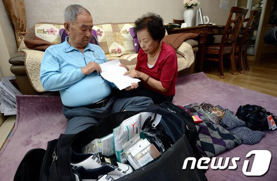 본문 이미지 - 북한이 오는 25일 금강산에서 열릴 예정이었던 추석 이산가족 상봉행사를 무기한 연기한다고 발표한 가운데 22일 오후 상봉 대상자인 김명도 할아버지(90세)가 부인 박현수(86세) 씨와 경기도 용인 자택에서 북한 가족의 생사확인서를 바라보고 있다. 21살때 대학 공부를 위해 서울로 내려온 김 할아버지는 "(당시에는) 왕래가 가능할 줄 알았지만 이렇게 되버렸다＂며 ＂상봉행사 연기는 인도적인 적십자정신이 아니다＂라고 말했다. 2013.9.22/뉴스1