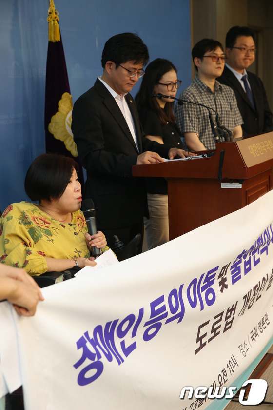 (서울=뉴스1) 송원영 기자 = 박원석 진보정의당 의원과 장애인차별금지추진연대 회원들이 23일 오전 서울 여의도 국회 정론관에서 장애인 등의 이동 및 출입편의시설 설치를 위한 도로 …