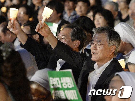 본문 이미지 - 문재인 민주당 의원이 23일 오후 서울광장에서 열린 '국정원 개혁과 정부의 회개를 촉구하는 시국미사'에 참석해 촛불을 들고 있다. 2013.9.23/뉴스1 © News1   박지혜 기자