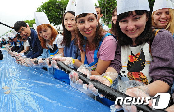 (대구=뉴스1) 김영진 기자 = 28일 오후 대구 수성구 들안길에서 열린 1020m 김밥말기 한국 기네스북 도전에 참가한 외국인과 시민들이 만든 김밥을 들어 보이며 즐거운 시간을 …