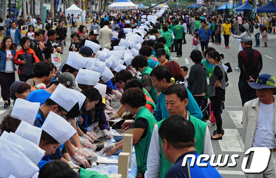 (대구=뉴스1) 김영진 기자 = 28일 오후 대구 수성구 들안길에서 열린 1020m 김밥말기 한국 기네스북 도전에 수많은 시민들이 몰려 인산인해를 이루고 있다. 2013.9.28/ …