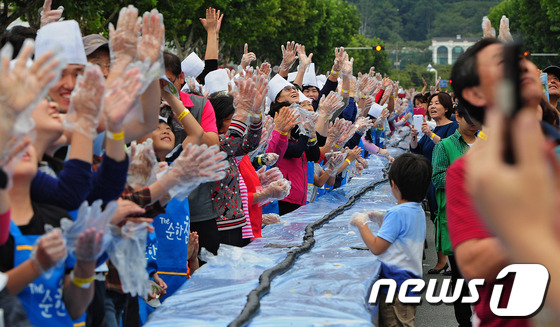 (대구=뉴스1) 김영진 기자 = 28일 오후 대구 수성구 들안길에서 열린 1020m 김밥말기 한국 기네스북 도전에 참가한 외국인과 시민들이 만든 김밥을 만든 후 박수를 치며 기쁨을 …