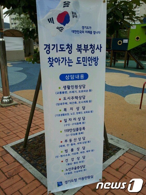 본문 이미지 - 경기도 찾아가는 도민안방이 6일 양주시 만송동 LH휴먼시아 아파트에서 찾는 이가 별로 없이 한산한 상태로 진행됐다. 가로수에 붙인 경기도 도민안방 홍보물. © News1 이상휼 기자 이상휼 기자