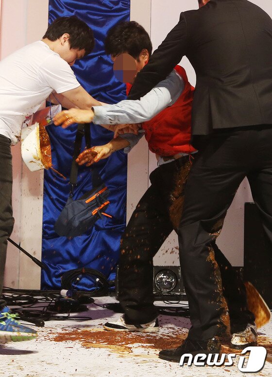 본문 이미지 - 7일 오후 서울 청계천 광통교에서 열린 김조광수 감독과 김승환 대표의 결혼식에 한 남성이 난입해 된장을 뿌린 뒤 끌려 나가고 있다. 2013.9.7 머니투데이/뉴스1  © News1   