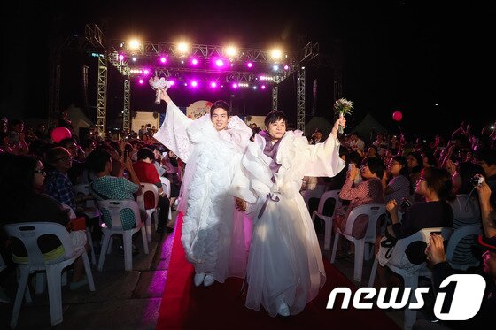 본문 이미지 - 국내 첫 동성결혼식을 올린 김조광수 감독과 김승환 레인보우팩토리 대표가 7일 오후 서울 청계천 광통교 앞에서 열린 '김조광수와 김승환의 당연한 결혼식, 어느 멋진 날'에서 행진하고 있다.이들은 결혼식 축의금과 올해 하반기, 내년 상반기 모금을 통해 성소수자 인권센터인 '신나는 센터'와 이를 운영하는 성소수자 인권 재단(가칭)을 설립할 계획이다. 누구나 공개된 계좌로 입금할 수 있다. 2013.9.7/뉴스1 © News1   유승관 기자