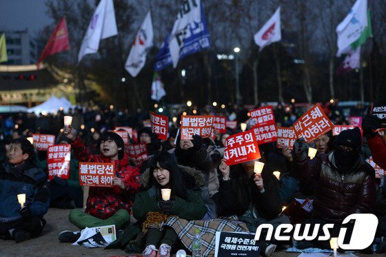 본문 이미지 - 11일 서울광장에서 열린 국가기관의 대선개입 의혹과 수사방해에 대한 진상 규명을 위한 국정원 시국회의 촛불집회에서 참석자들이 구호를 외치고 있다. 2014.1.11/뉴스1 © News1   안은나 기자
