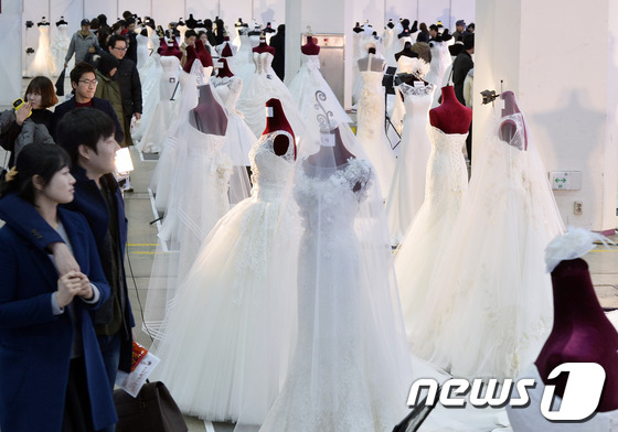 (서울=뉴스1) 최영호 기자 = 12일 오후 서울 강남구 코엑스에서 열린 제41회 웨덱스코리아를 찾은 한 예비신혼부부가 웨딩드레스를 살펴보고 있다.2014.1.12/뉴스1