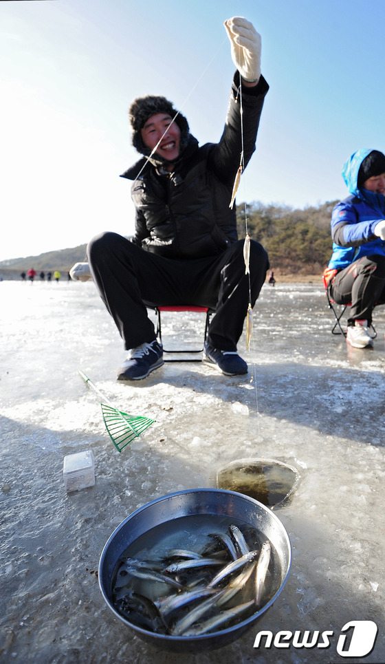 (대구=뉴스1) 김영진 기자 = 연일 한파가 지속되고 있는 14일 오후 경북 군위군 소보면 한 저수지에서 시민들이 얼음낚시를 하며 즐거운 시간을 보내고 있다. 2014.1.14/뉴 …