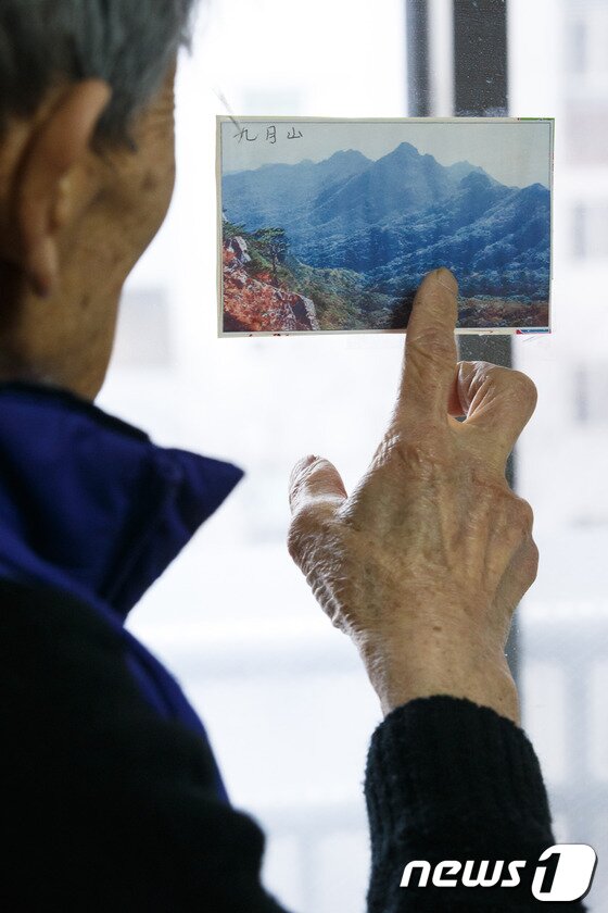본문 이미지 - 강능환(93) 할아버지가 서울 송파구 자택에서 고향인 황해도 구월산 사진을 바라보고 있다.  2014.1.27/뉴스1