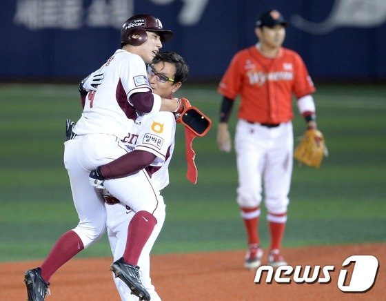 본문 이미지 - 17일 오후 서울 목동야구장에서 열린 2014 한국야쿠르트 세븐 프로야구 넥센히어로즈와 SK와이번스의 경기에서 넥센 1회말 선두타자 서건창이 첫타석 안타를 치며 200안타를 달성 심재학코치가 얼싸 안으며 축하하고 있다. 여년, 20여년 묵은 기록을 넘어선 것이다. 서건창은 타격 1위까지 3관왕을 노리고 있다. 2014.10.17/뉴스1 ⓒ News1 이동원 기자