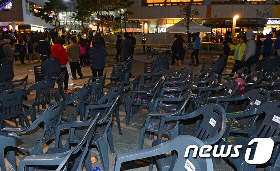 본문 이미지 - 17일 저녁 경기 성남시 분당구 판교동 유스페이스 앞 야외 공연장 주변 환풍기 붕괴 추락사고가 발생했다. 사고현장 주변에 간이 의자들이 널려 있다. 이날 오후 5시53분께 경기 성남시 분당구 판교동 유스페이스 앞 야외 공연장에서 관람객 약25명이 지하철 환풍구 아래(10m)로 추락하는 사고가 발생했다. 사고는 걸그룹 포미닛 공연장 주변 지하철 환풍구가 위에서 관람하던 팬들의 무게를 버티지 못하고 환풍기 뚜껑이 아래로 꺼지면서 발생했다. 소방당국은 "오후 8시 현재 25명이 추락해 15명이 사망한 것으로 집계하고 있다. 이날 공연은 제1회 판교 테크노벨리 축제의 일환으로 마련된 것으로, 걸그룹 티아라 등 인기가수들이 출연할 예정이었다. 2014.10.17/뉴스1 ⓒ News1 김영진 기자