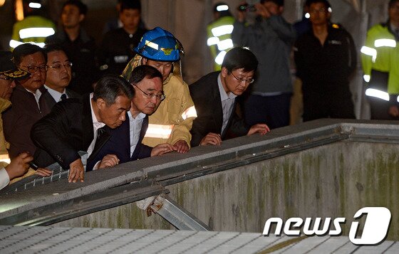 본문 이미지 - 정홍원 국무총리가 17일 저녁 경기 성남시 분당구 판교동 유스페이스 앞 야외 공연장 주변 환풍기 붕괴 추락사고 현장을 찾아 소방관계자로부터 사고경위를 듣고 있다. 이날 오후 5시53분께 경기 성남시 분당구 판교동 유스페이스 앞 야외 공연장에서 관람객 약25명이 지하철 환풍구 아래(10m)로 추락하는 사고가 발생했다. 사고는 걸그룹 포미닛 공연장 주변 지하철 환풍구가 위에서 관람하던 팬들의 무게를 버티지 못하고 환풍기 뚜껑이 아래로 꺼지면서 발생했다. 2014.10.17/뉴스1 ⓒ News1 김영진 기자
