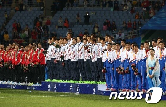 본문 이미지 - 지난 2014년 10월 인천 문학경기장에서 열린 2014 인천아시안게임 남자 축구 결승에서 북한을 꺽고 금메달을 차지한 한국 대표팀 선수들이 시상대에 올라 애국가를 부르고 있다. /뉴스1 ⓒ News1