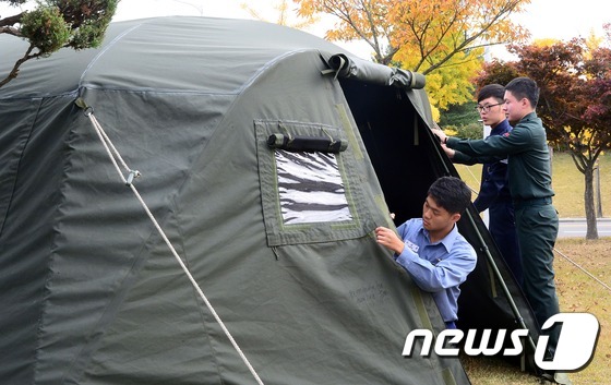 (계룡=뉴스1) 장수영 기자 = 30일 충남 계룡시 계룡대에서 열린 '군수품 품질개선을 위한 군수품 품평회'에서 군 장병들이 분대전투형 천막을 살펴보고 있다. 2014.10.30/ …