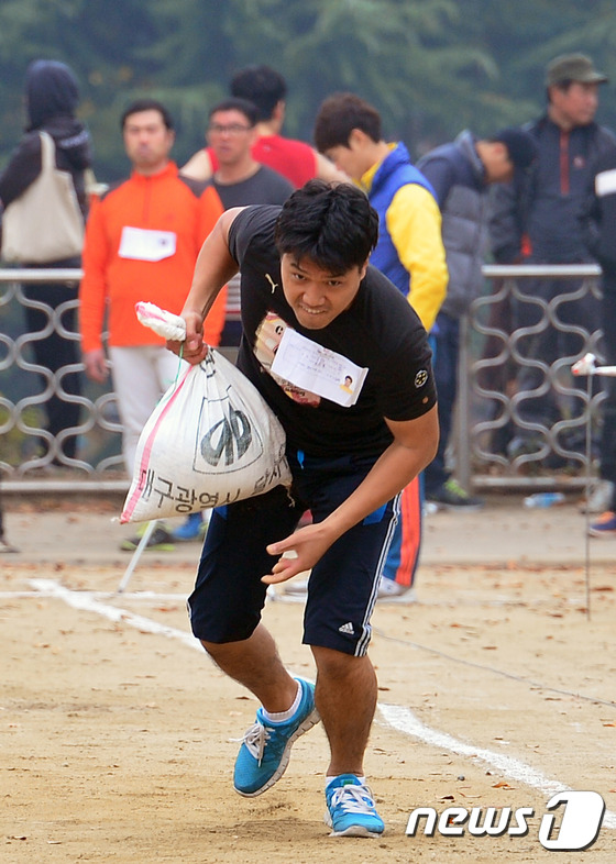 (대구ㆍ경북=뉴스1) 정훈진 기자 = 8일 대구시 달서구 학산공원 운동장에서 환경미화원 채용 체력검사가 열려 채용에 참가한 한 응시자가 모래자루 (20kg)를 한손으로 들고 전력질 …