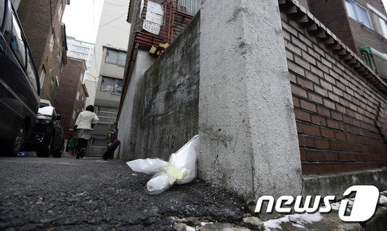 2014년 12월 23일 오후 여행용 가방에서 시신이 발견된 인천 남동구 간석동 모 빌라 앞에 조화가 놓여져 있다.  가방안 시신은 A 씨&#40;71·여&#41;로 인천 부평구에서 야채장사를 하던 할머니였다. 2014.12.23/뉴스1 ⓒ News1 박지혜 기자