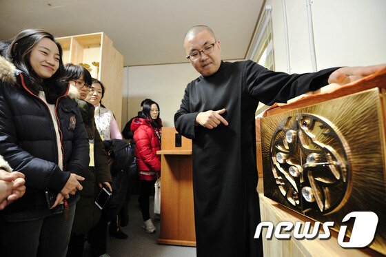 본문 이미지 - 고진석 이사악 신부(40) 가 경북 칠곡군 성 베네딕도회 왜관 수도원에서 열린 '공지영 작가와 함께하는 1박2일 수도원 체험'에서 수도사들의 금속공예 기술로 만든 감실에 대해 설명하고 있다. 2014.12.27/뉴스1 ⓒ News1 정훈진 기자