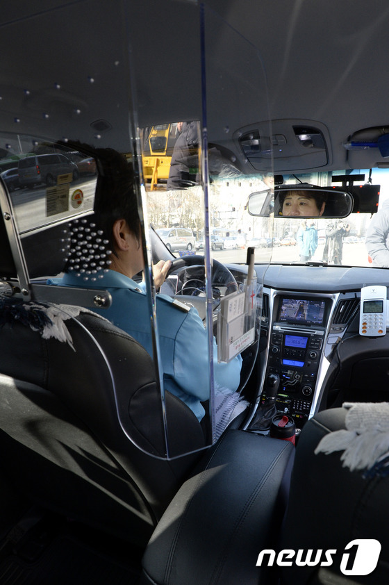 (서울=뉴스1) 안은나 기자 = 4일 오후 서울광장 옆 도로에서 택시기사 최옥자씨가 보호격벽이 설치된 택시를 타고 있다. 서울시는 택시 운수종사자 보호를 위해 보호격벽 설치비용의 …