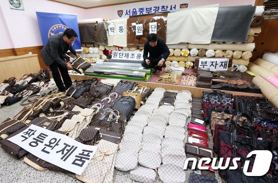 (서울=뉴스1) 오대일 기자 = 9일 오후 서울 중구 중부경찰서에서 열린 동대문 시장 짝퉁 원단 제작·판매 일당 검거 브리핑에서 수사관들이 루이비통 등 명품 브랜드 짝퉁 원단과 원 …