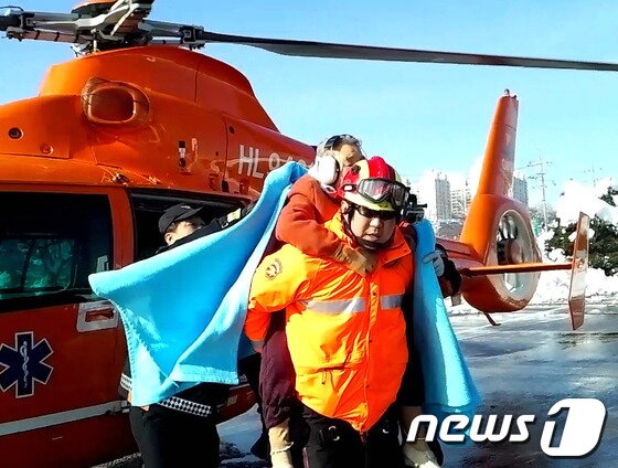 본문 이미지 - 12일 오전 10시 35분께 삼척시 노곡면 개산리 고봉암 인근의 한 주택에 고립됐던 장모씨&#40;91·여&#41;가 소방대원의 도움으로 구조되고 있다.엿새간 쏟아진 폭설로 지난 6일부터 고립된 장 할머니와 한 방송국 촬영팀이 일주일 만에 무사히 구조됐다.&#40;삼척소방서 제공&#41; 2014.2.12/뉴스1 © News1   이예지 기자