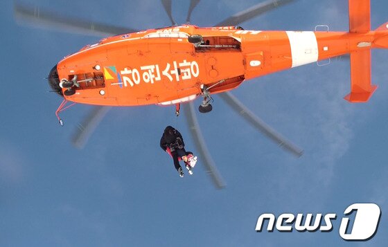 본문 이미지 - 12일 오전 10시 35분께 삼척시 노곡면 개산리 고봉암 인근의 한 주택에 고립됐던 장모씨&#40;91·여&#41;가 소방대원의 도움으로 소방헬기에 오르고 있다.엿새간 쏟아진 폭설로 지난 6일부터 고립된 장 할머니와 한 방송국 촬영팀이 일주일 만에 무사히 구조됐다.&#40;사진제공=삼척소방서&#41; 2014.2.12/뉴스1 © News1 