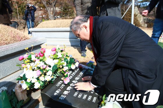 본문 이미지 - 천주교 서울대교구장 염수정 추기경이 14일 오전 경기 용인 천주교 공원묘지를 찾아 선배 사제이자 스승인 김수환 추기경 묘비에 손을 얹고 기도를 하고 있다. (천주교서울대교구 제공) 2014.2.14/뉴스1 © News1 