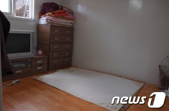 본문 이미지 - 지적장애인 채모씨가 거주한 숙소. 소금가마니가 쌓인 창고 안쪽에 조립식 판넬로 만들었다. 바닥에 전기장판이 깔려 있고 이불과 TV 등이 놓여있다© News1 
