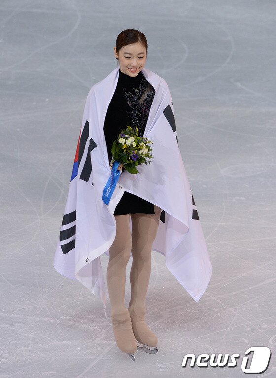 본문 이미지 - '피겨 여왕' 김연아가 21일(한국시간) 러시아 소치 해안 클러스터 아이스버그 스케이팅 팔라스 경기장에서 열린 프리 스케이팅 경기 후 꽃다발과 태극기를 몸에 두르고 있다. 김연아는 144.19점을 받아 전날 쇼트에서 받은 74.92점을 합산해 총점 219.11점으로 러시아의 소트니코바에 이어 은메달을 차지했다. 2014.2.21/뉴스1 © News1 (소치(러시아)=뉴스1) 이동원 기자
