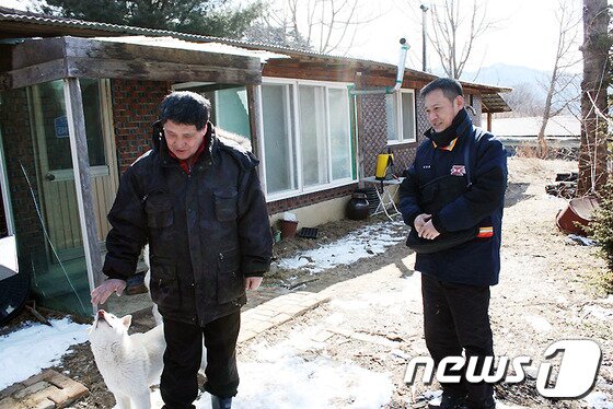 본문 이미지 - 양구군 양구읍 상무룡리  우편물 배달을 담당하는 김동훈 집배원과 상무룡2리&#40;서호마을&#41; 이장 홍순하씨. 그리고 이들 옆에는 서호마을 길잡이 백구.&#40;강원지방우정청 제공&#41;.2014.2.21/뉴스1 © News1   권혜민 기자