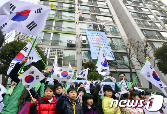 (서울=뉴스1) 최영호 기자 = 제95주년 3.1절을 앞두고 25일 오전 서울 성동구 사근동 중앙하이츠아파트에서 주민들과 아이들이 태극기를 흔들고 있다.성동구는 순국선열의 숭고한 …