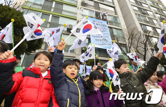 (서울=뉴스1) 최영호 기자 = 제95주년 3.1절을 앞두고 25일 오전 서울 성동구 사근동 중앙하이츠아파트에서 주민들과 아이들이 태극기를 흔들고 있다.성동구는 순국선열의 숭고한 …